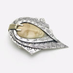 Zealandia Pendant Brooch, Woman wearing a head scarf, Sterling Silver and carved fossil tusk.
