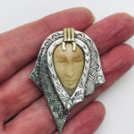 Zealandia Pendant Brooch, Woman wearing a head scarf, Sterling Silver and carved fossil tusk.