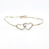 Hand wrought sterling silver cuff bracelet with hammered finish and interlocking double heart centerpiece