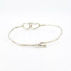 Hand wrought sterling silver cuff bracelet with hammered finish and interlocking double heart centerpiece