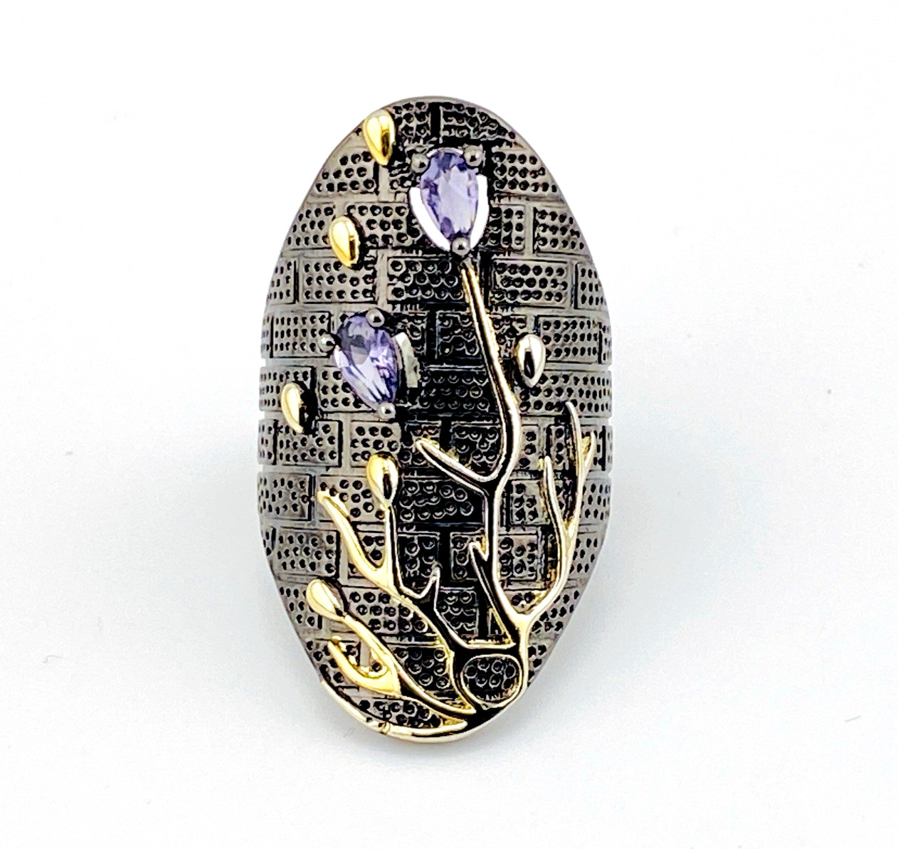 Front of Black rhodium sterling silver statement ring with gold coral branch design and pear-shaped amethyst color stones in an elongated oval silhouette