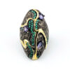 Black rhodium sterling silver statement ring with gold accents, green cubic zirconia, and pear-shaped amethyst stones in an elongated modernist design