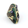 Black rhodium sterling silver statement ring with gold accents, green cubic zirconia, and pear-shaped amethyst stones in an elongated modernist design