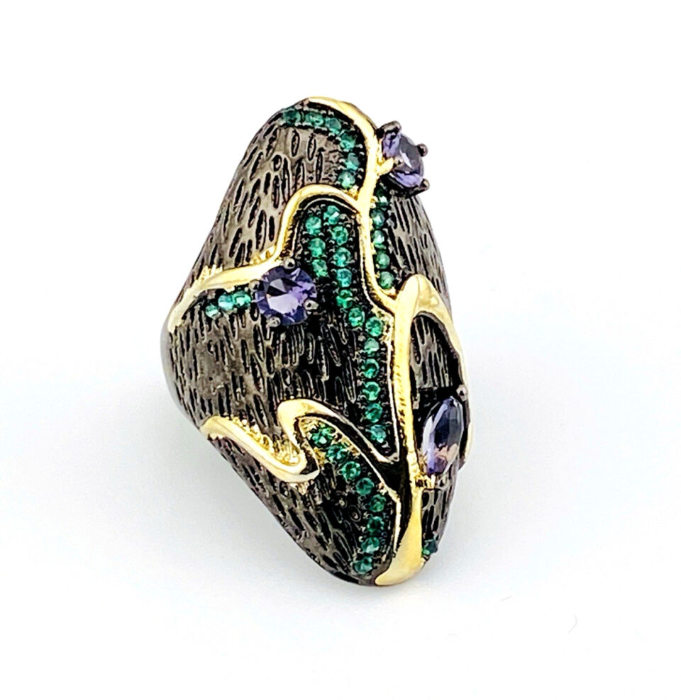 Black rhodium sterling silver statement ring with gold accents, green cubic zirconia, and pear-shaped amethyst stones in an elongated modernist design