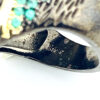 Black rhodium sterling silver statement ring with gold accents, green cubic zirconia, and pear-shaped amethyst stones in an elongated modernist design