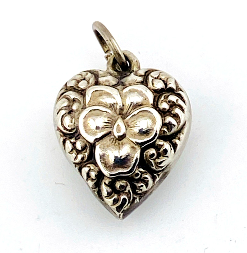 Victorian sterling silver puffy heart pendant with repoussé scrollwork, applied pansy flower, and engraved initials on the back.