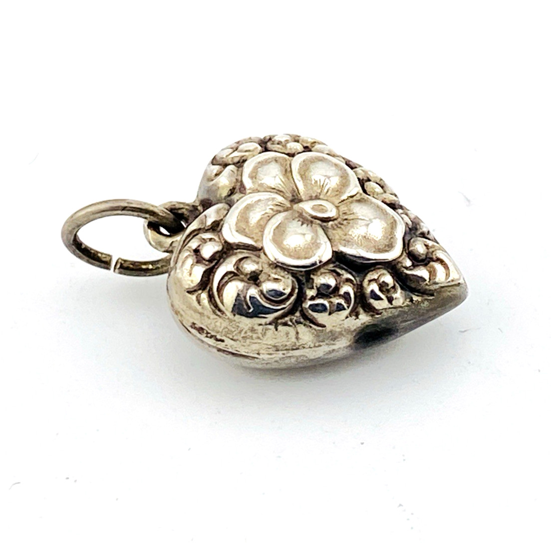 Victorian sterling silver puffy heart pendant with repoussé scrollwork, applied pansy flower, and engraved initials on the back.