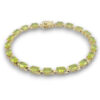 Vintage gold over sterling silver line bracelet with twenty oval faceted peridot gemstones arranged in a continuous row