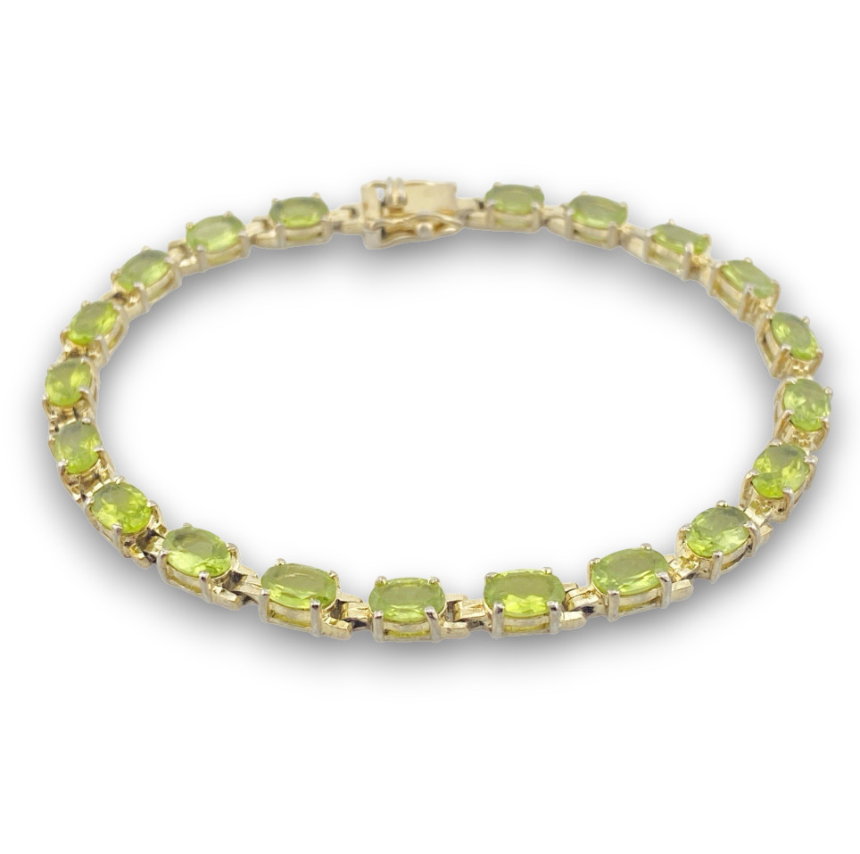Vintage gold over sterling silver line bracelet with twenty oval faceted peridot gemstones arranged in a continuous row
