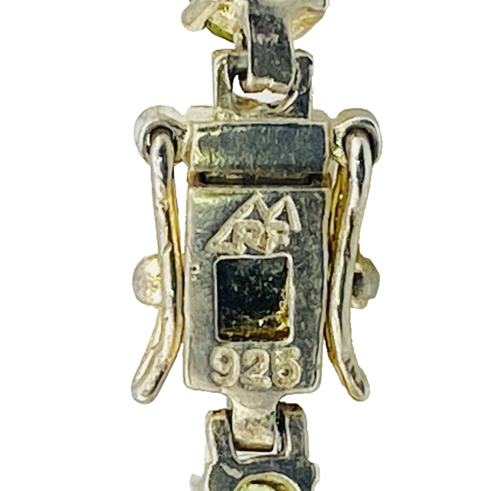 Vintage gold over sterling silver line bracelet with twenty oval faceted peridot gemstones arranged in a continuous row
