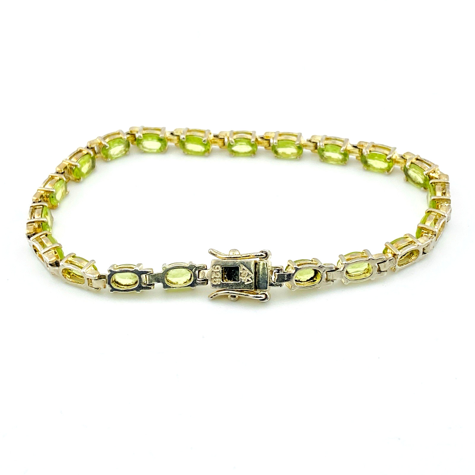 Vintage gold over sterling silver line bracelet with twenty oval faceted peridot gemstones arranged in a continuous row