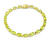 Vintage gold over sterling silver line bracelet with twenty oval faceted peridot gemstones arranged in a continuous row
