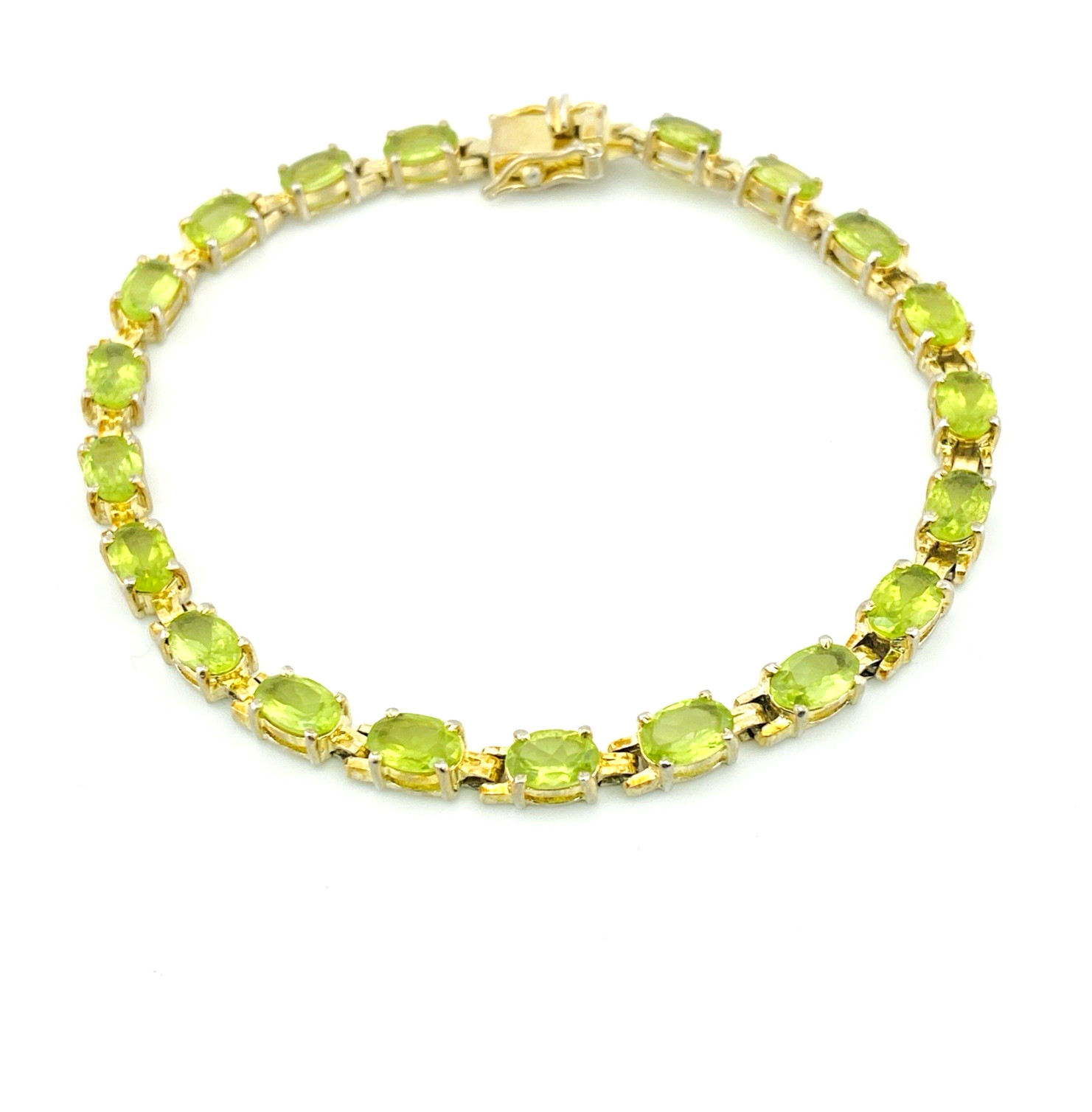 Vintage gold over sterling silver line bracelet with twenty oval faceted peridot gemstones arranged in a continuous row