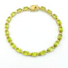 Vintage gold over sterling silver line bracelet with twenty oval faceted peridot gemstones arranged in a continuous row