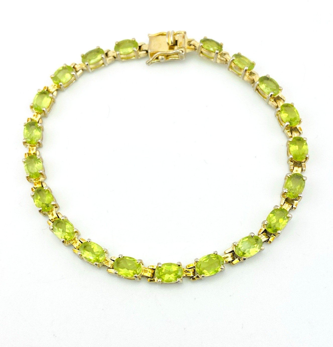 Vintage gold over sterling silver line bracelet with twenty oval faceted peridot gemstones arranged in a continuous row