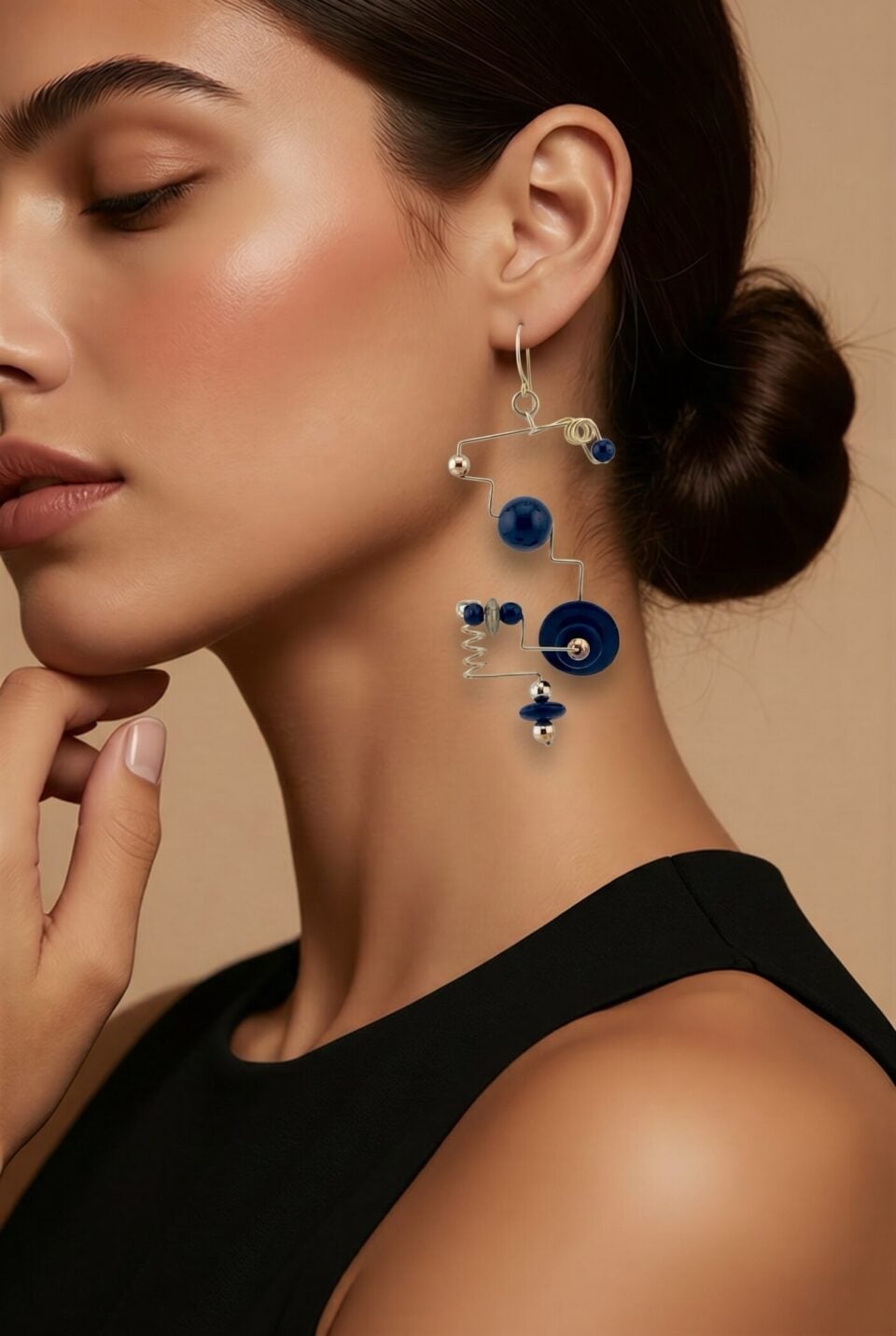 Modernist geometric dangle earrings in gold filled wire with black glass beads sculptural design on a model for illustration