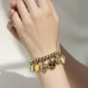 Vintage gold filled charm bracelet with fifteen locket charms including hearts book and enamel designs