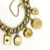 Vintage gold filled charm bracelet with fifteen locket charms including hearts book and enamel designs