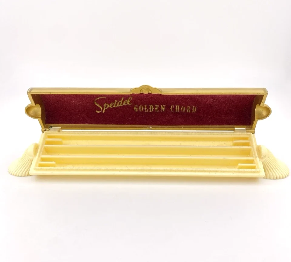 Vintage Speidel Golden Chord watch band box with textured beige plastic and gold accents from the 1950s