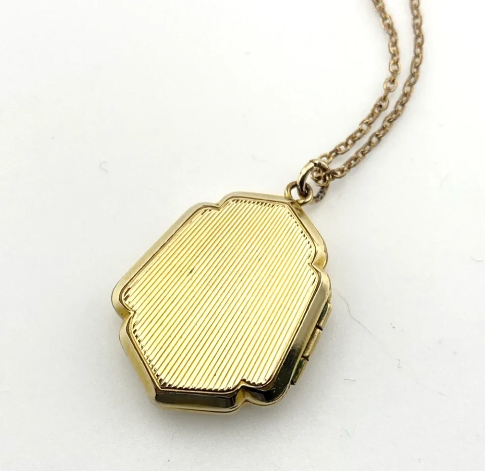 Edwardian gold filled shield shaped locket necklace with floral engraved front, pinstripe back, antique photo inside, and 21 inch chain