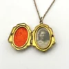 Edwardian gold filled shield shaped locket necklace with floral engraved front, pinstripe back, antique photo inside, and 21 inch chain