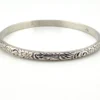 Antique P&H sterling silver bangle bracelet with carved scrolls, vines, leaves, and forget-me-not flowers.