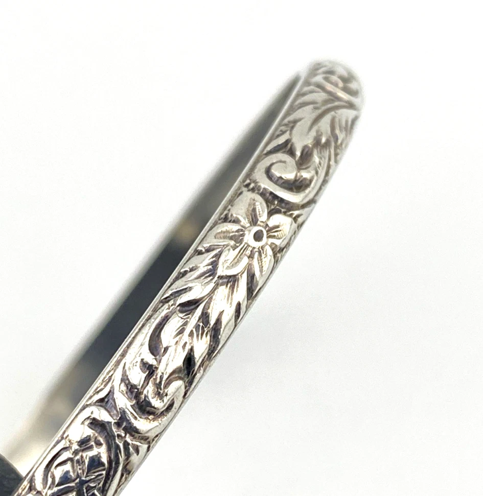 Antique P&H sterling silver bangle bracelet with carved scrolls, vines, leaves, and forget-me-not flowers.