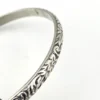Antique P&H sterling silver bangle bracelet with carved scrolls, vines, leaves, and forget-me-not flowers.