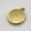 Antique Hayward 1/20 12K gold filled round photo locket with chased shield cover, floral garland, pinstripe back, and interior photo frames