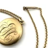 Antique Victorian gold filled round locket necklace with paste stone edging, bloomed gold finish, engraved EM monogram, and 21 inch chain