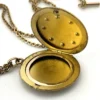 Antique Victorian gold filled round locket necklace with paste stone edging, bloomed gold finish, engraved EM monogram, and 21 inch chain