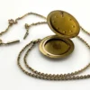 Antique Victorian gold filled round locket necklace with paste stone edging, bloomed gold finish, engraved EM monogram, and 21 inch chain