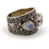 Vintage India sterling silver cigar band ring with three faceted blue flash moonstones and ornate raised silverwork.
