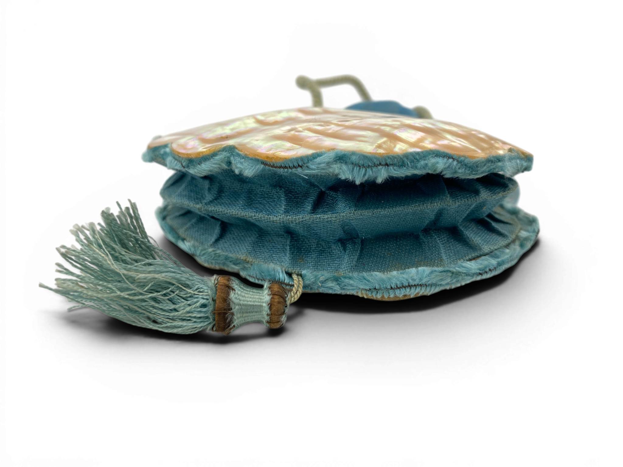 Antique Art Nouveau era mother-of-pearl and blue silk necessaire purse with scalloped shell panels, rope handles, and tassel.