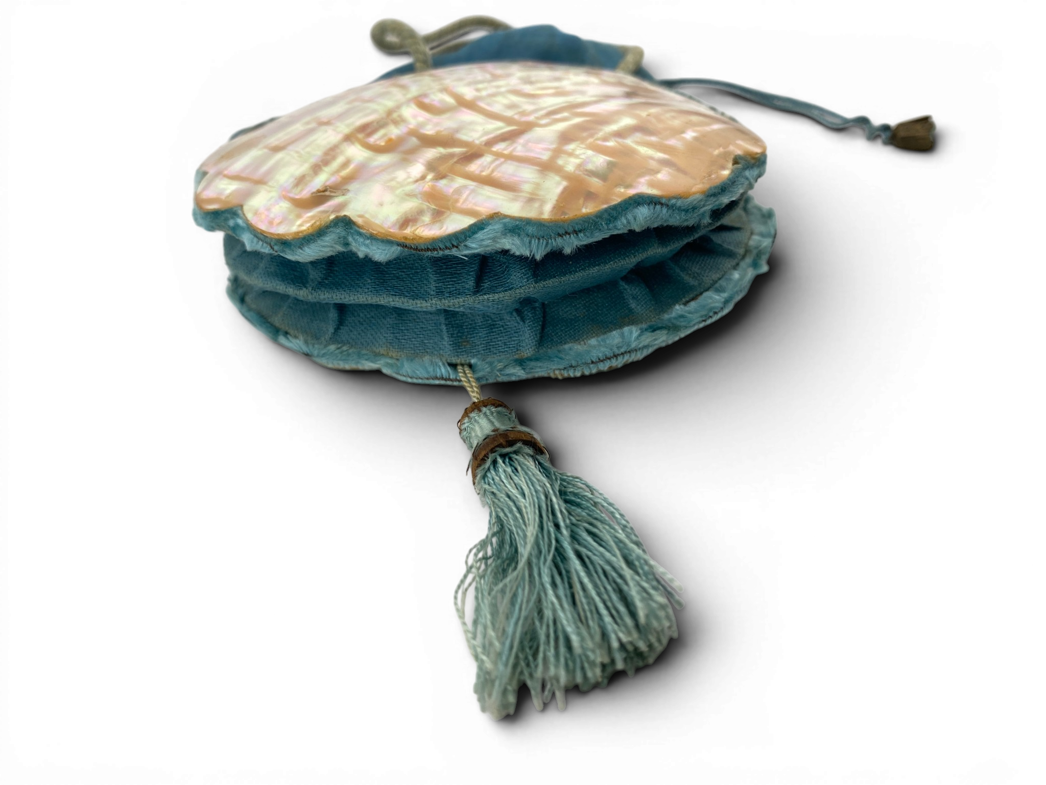 Antique Art Nouveau era mother-of-pearl and blue silk necessaire purse with scalloped shell panels, rope handles, and tassel.