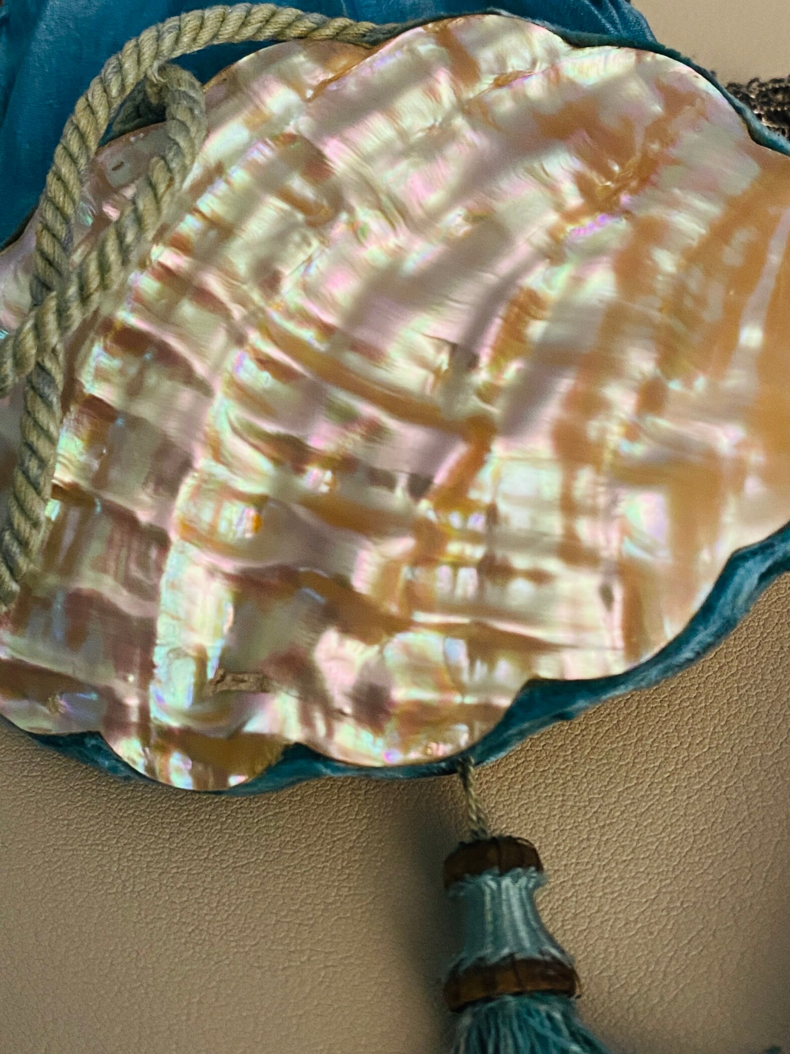 Antique Art Nouveau era mother-of-pearl and blue silk necessaire purse with scalloped shell panels, rope handles, and tassel.
