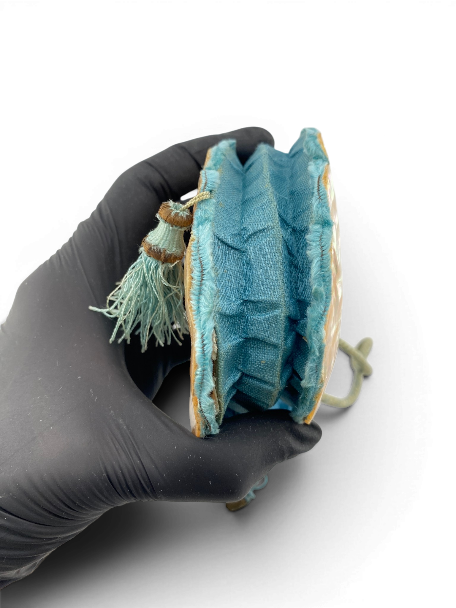 Antique Art Nouveau era mother-of-pearl and blue silk necessaire purse with scalloped shell panels, rope handles, and tassel.