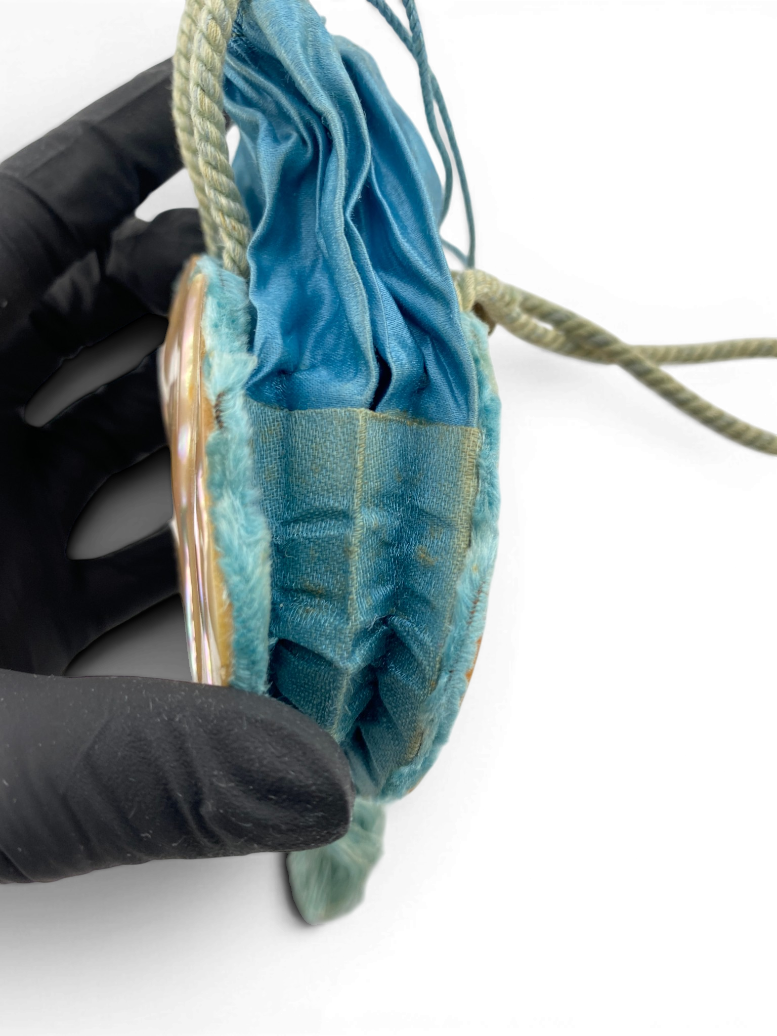 Antique Art Nouveau era mother-of-pearl and blue silk necessaire purse with scalloped shell panels, rope handles, and tassel.