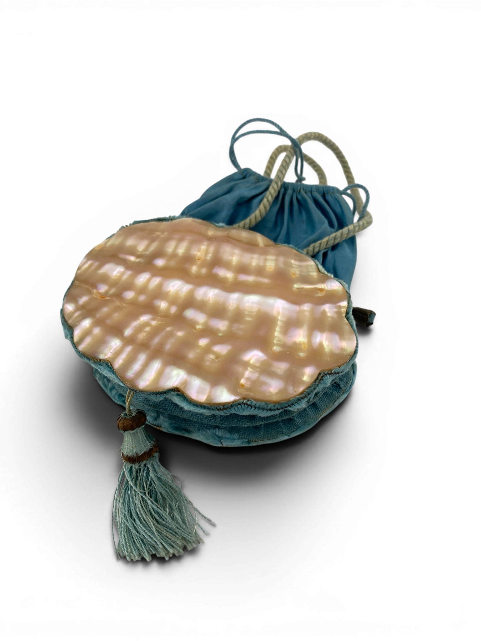 Antique Art Nouveau era mother-of-pearl and blue silk necessaire purse with scalloped shell panels, rope handles, and tassel.