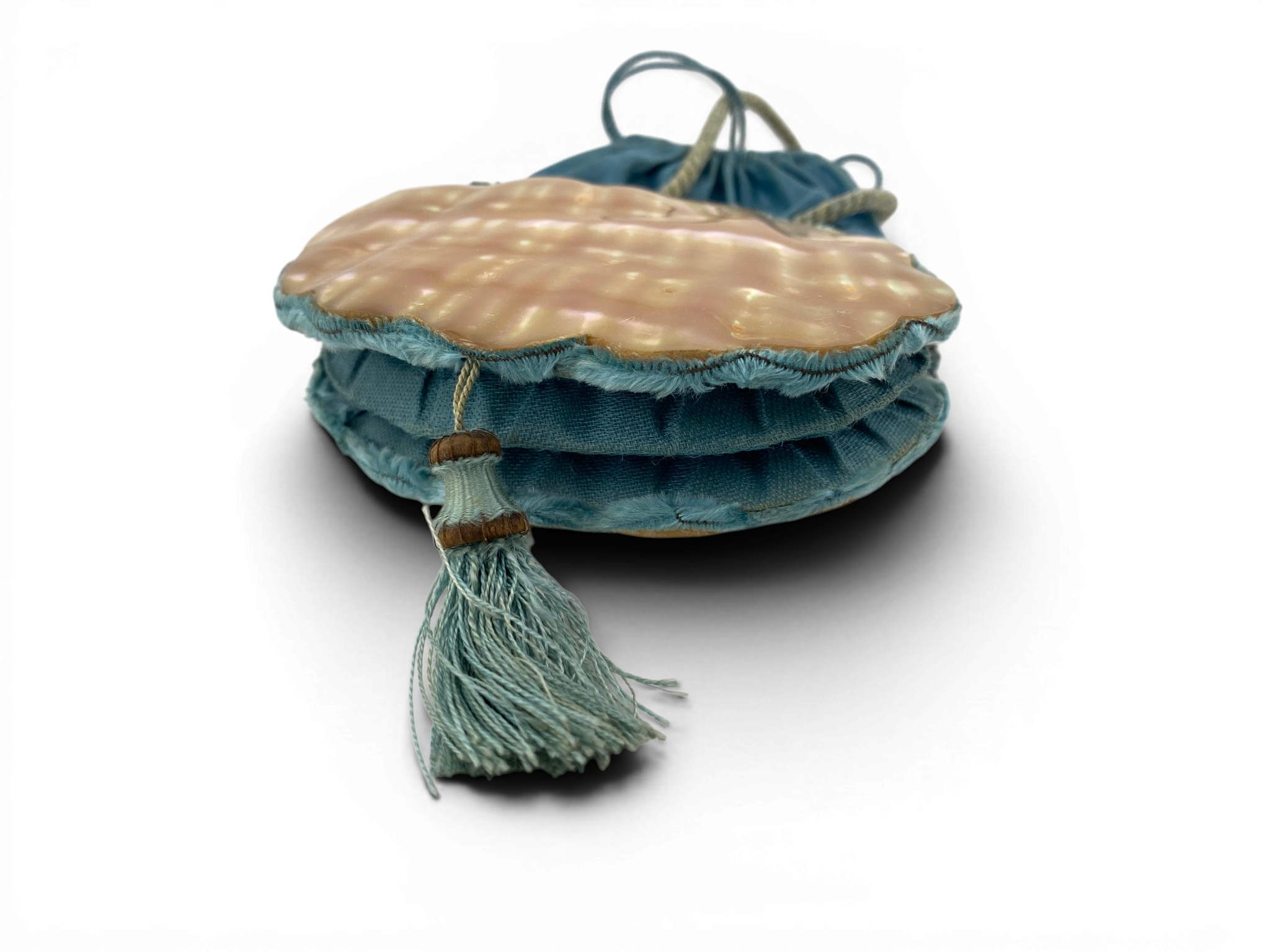 Antique Art Nouveau era mother-of-pearl and blue silk necessaire purse with scalloped shell panels, rope handles, and tassel.