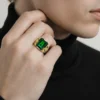 Vintage Mexican biker brass ring with green faceted glass stone and Our Lady of Guadalupe shoulders
