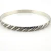 Vintage Danecraft sterling silver bangle bracelet with raised spiral rope design and carved scroll details.