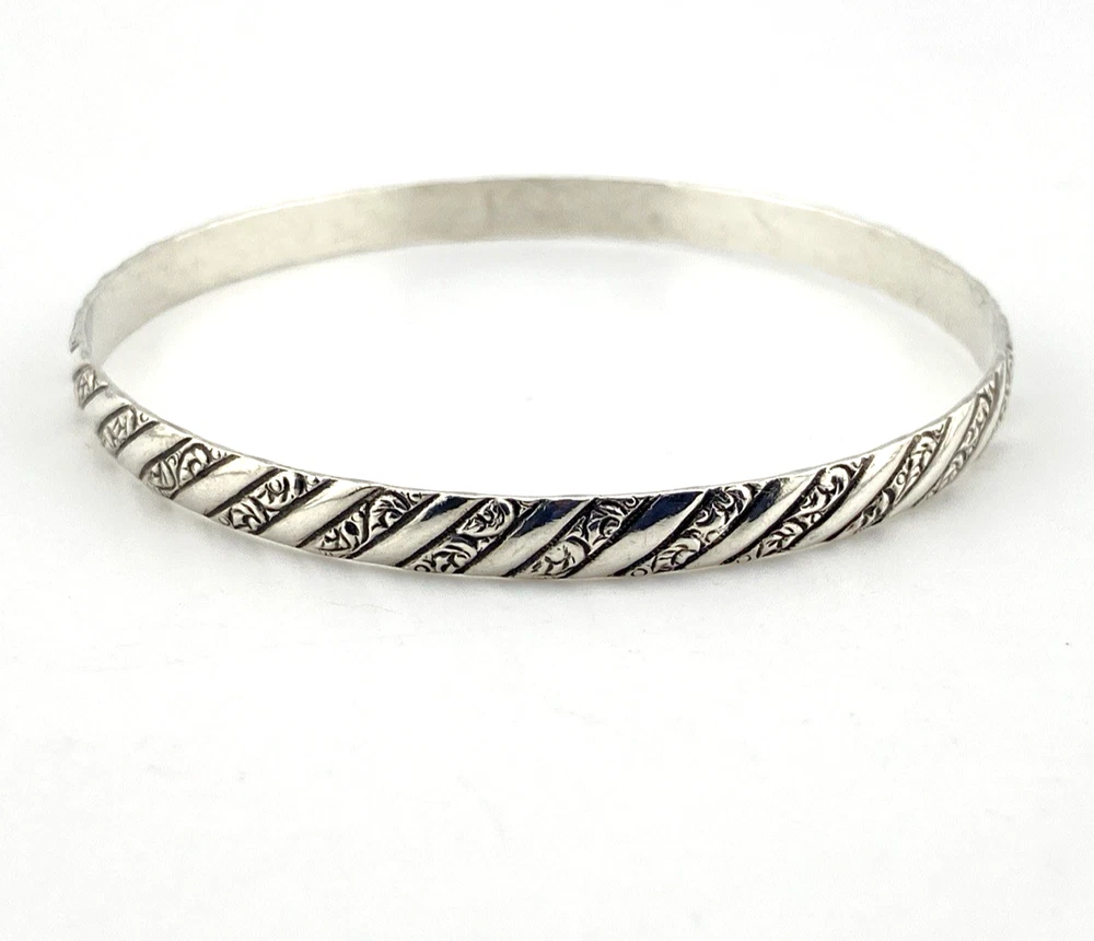 Vintage Danecraft sterling silver bangle bracelet with raised spiral rope design and carved scroll details.