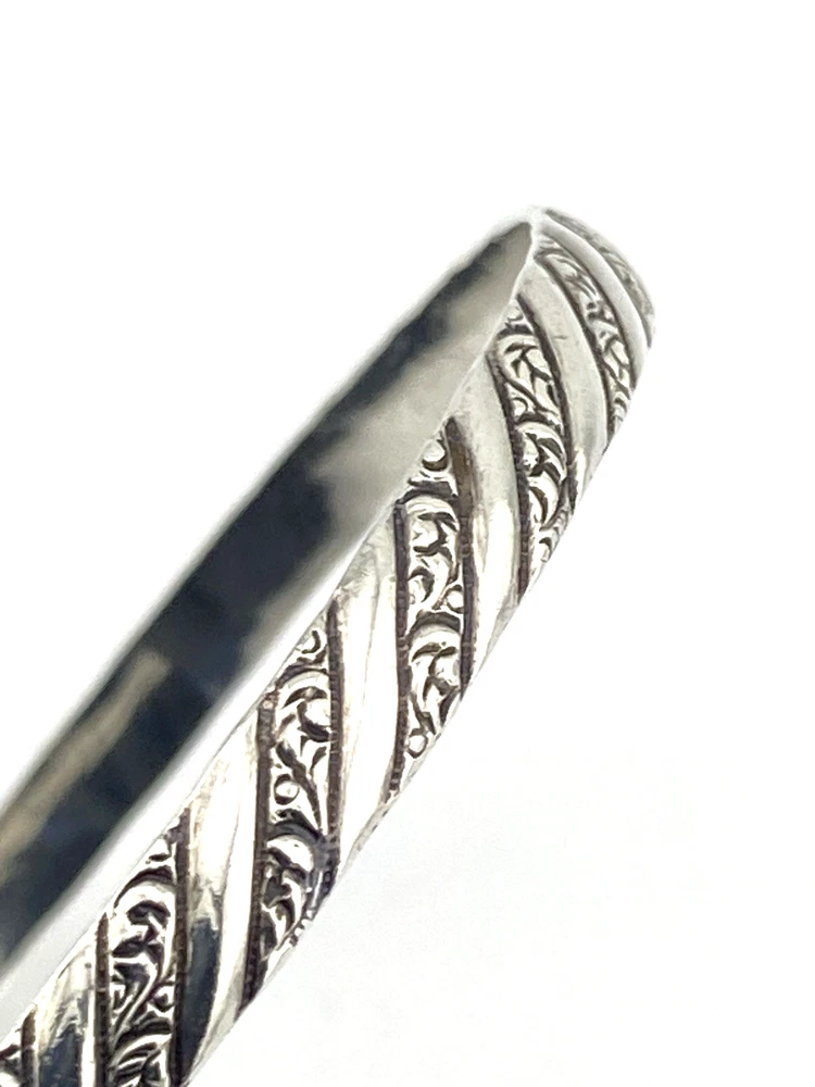 Vintage Danecraft sterling silver bangle bracelet with raised spiral rope design and carved scroll details.