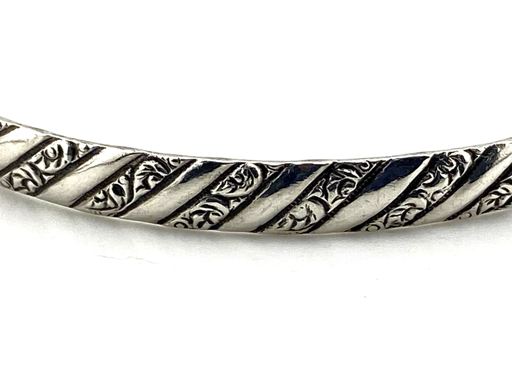 Vintage Danecraft sterling silver bangle bracelet with raised spiral rope design and carved scroll details.