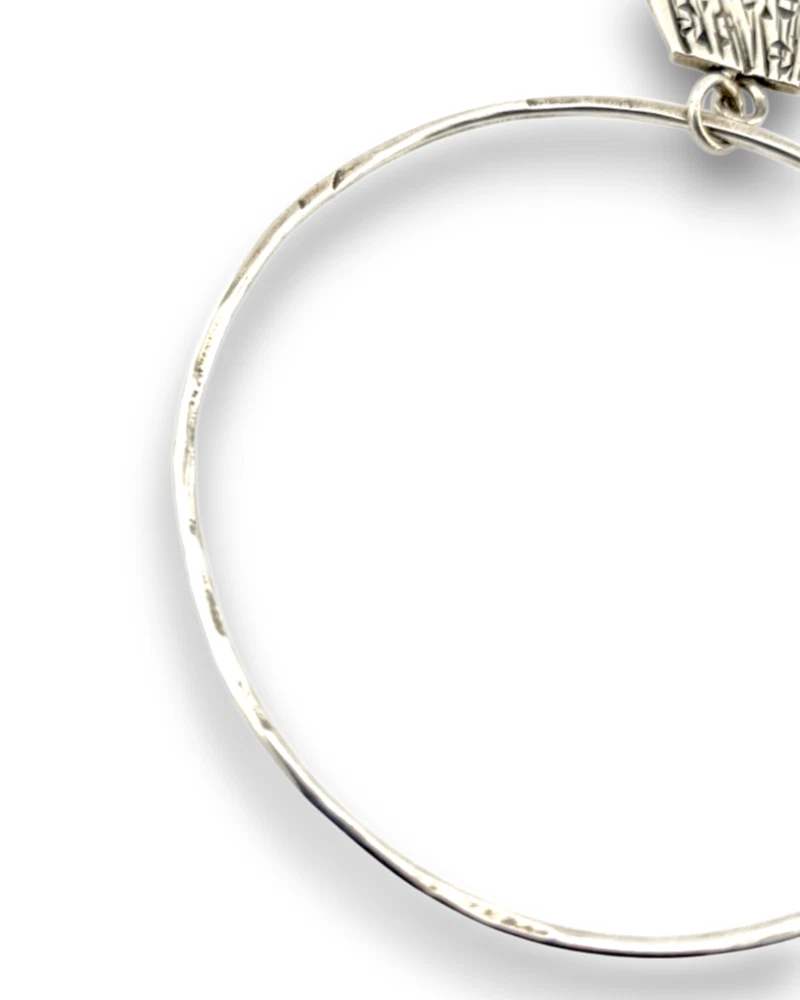 Hand wrought sterling silver studio bangle bracelet with trapezoid charm and organic stamped texture.