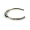 Vintage sterling silver cuff bracelet with eleven small turquoise snake-eye cabochons.