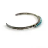 Vintage sterling silver cuff bracelet with eleven small turquoise snake-eye cabochons.