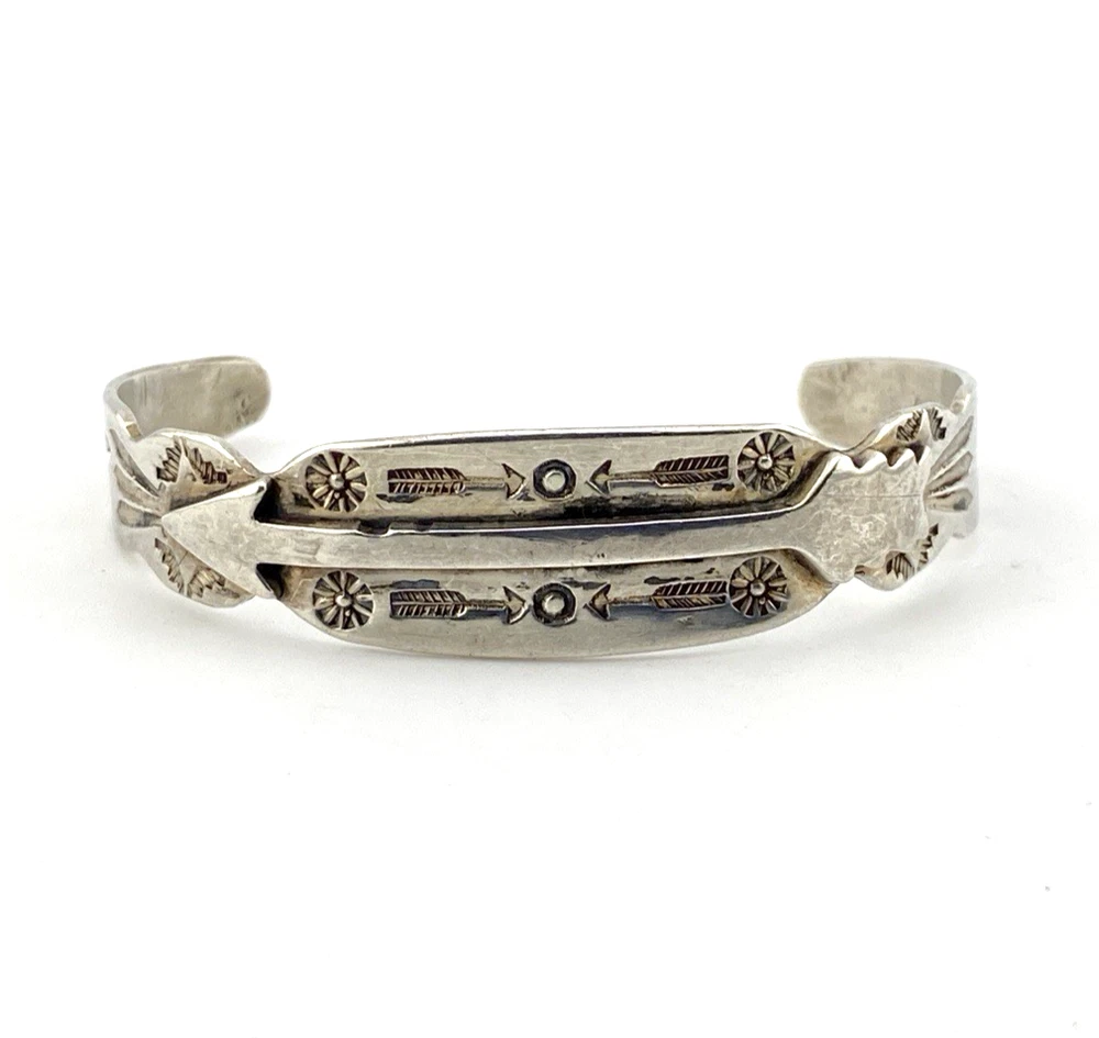 Vintage 1920s–1930s Navajo Fred Harvey era silver cuff bracelet with applied arrows, hand stamped motifs, and lizard-like markings.