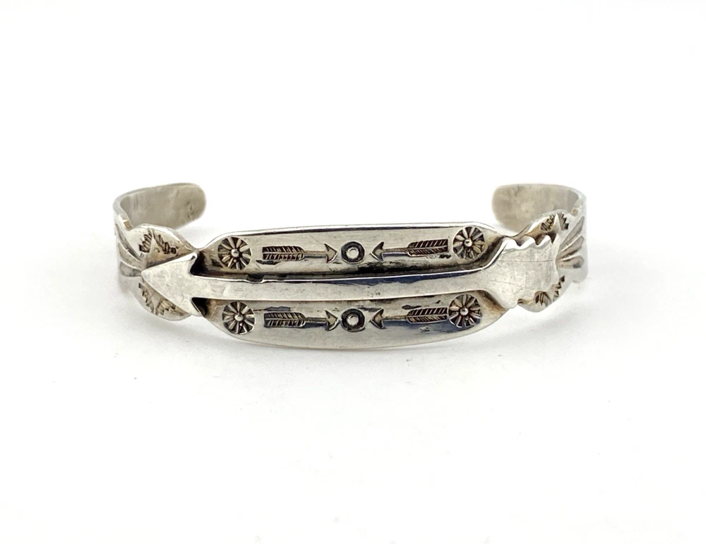 Vintage 1920s–1930s Navajo Fred Harvey era silver cuff bracelet with applied arrows, hand stamped motifs, and lizard-like markings.